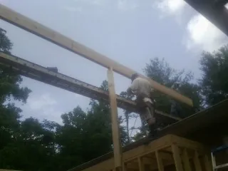 Carpenter setting a ridge beam over a new addition frame — Ice Dam Removal by Roofing Brothers in Beach City