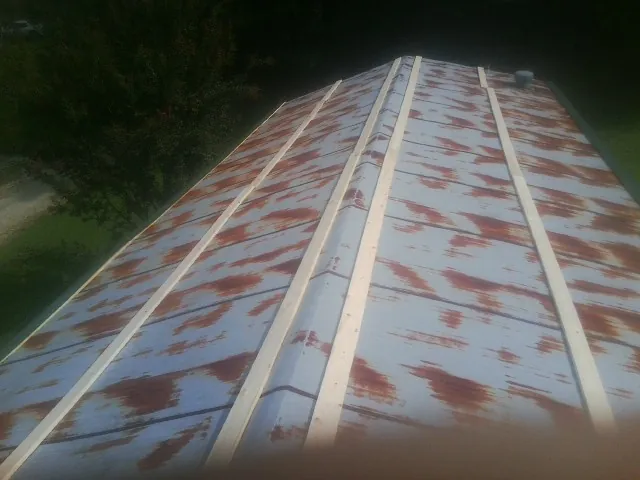 Rusted metal roof panels with new wood purlins before replacement — Storm Damage Roof Repair in Beach City by Roofing Brothers
