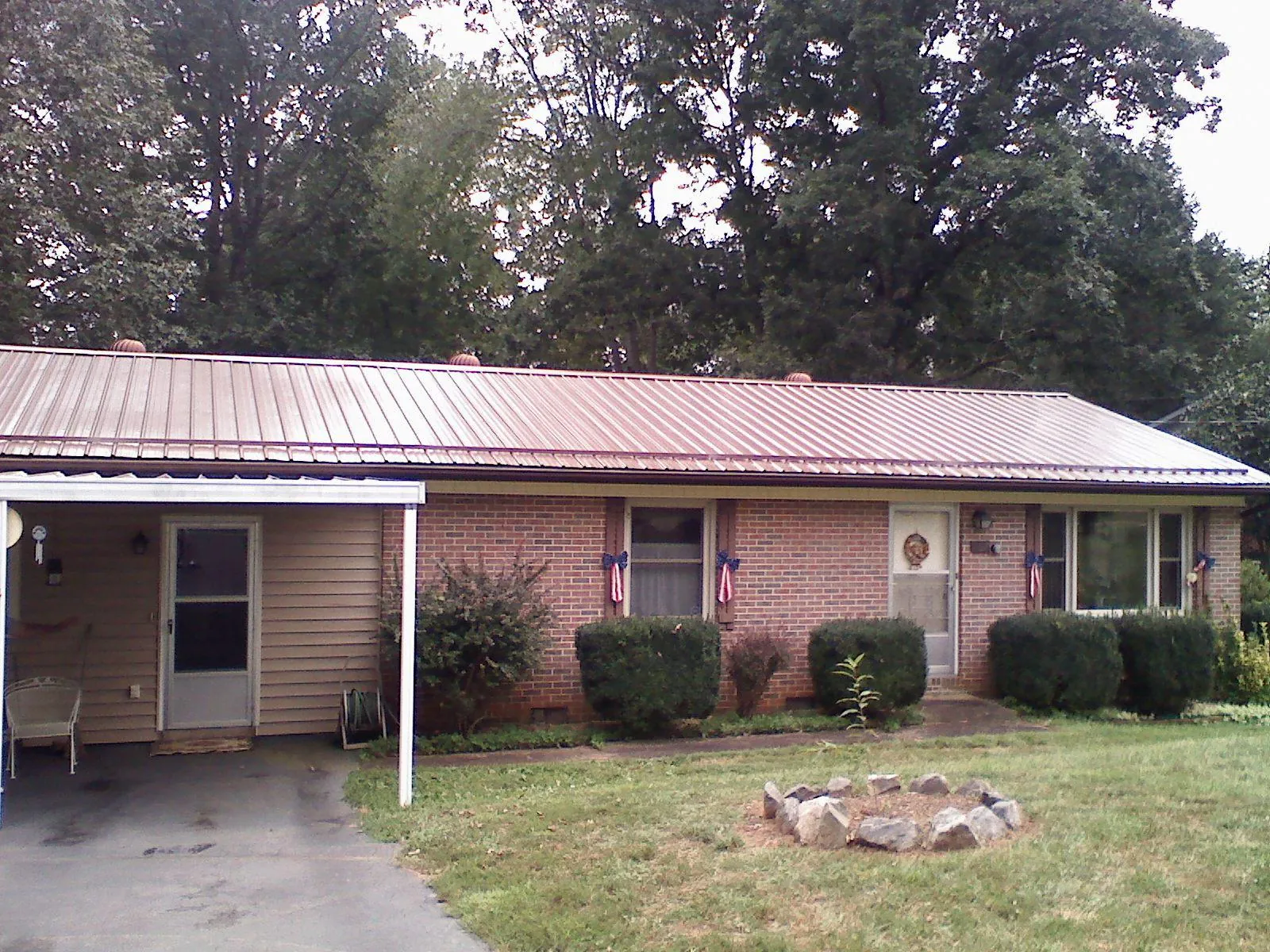 Bronze metal roof and carport on a brick ranch home — Roof Repair work by our crew in Beach City