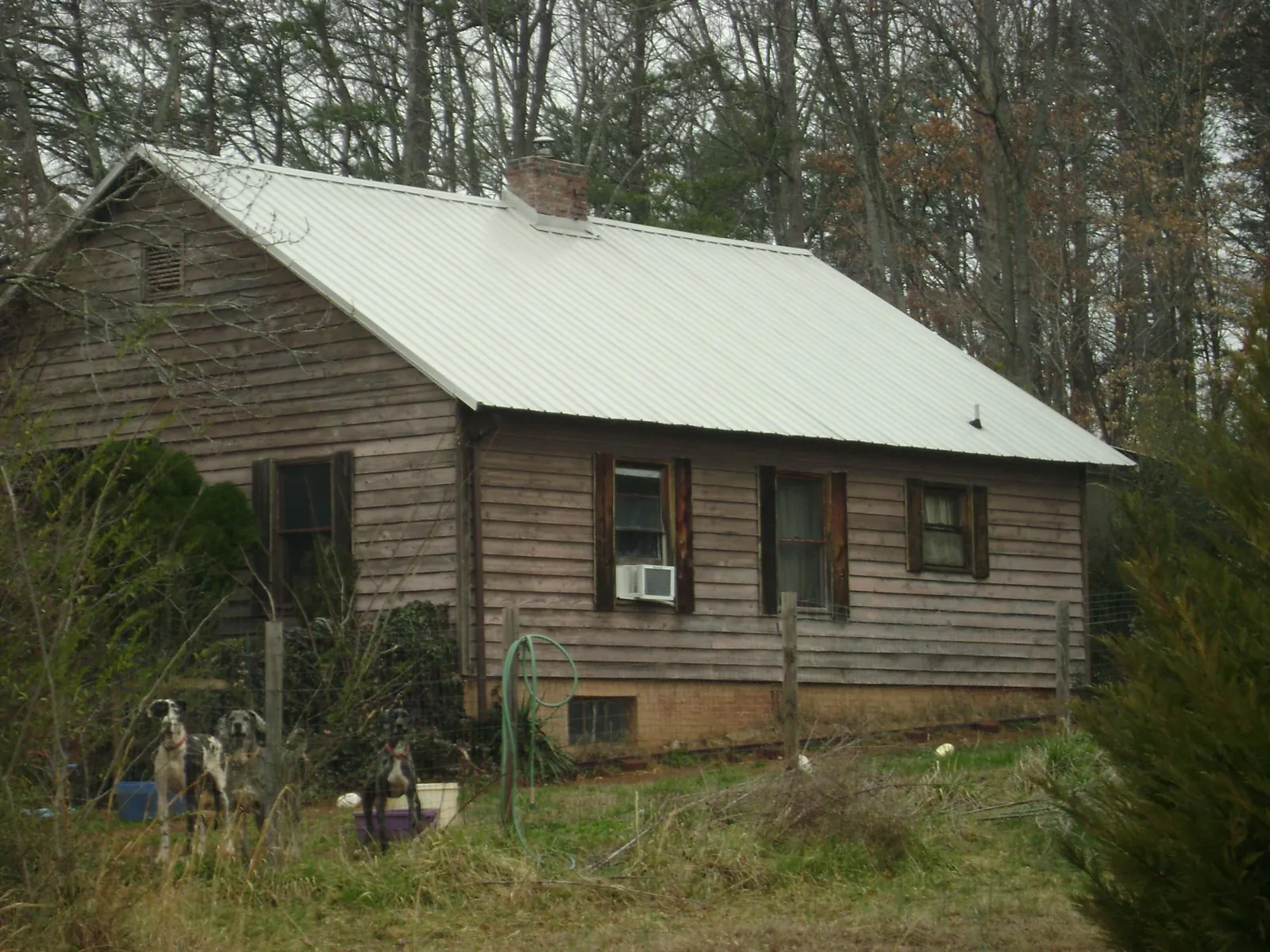 White metal roof on an old wood sided farmhouse, from a Metal Roof Installation job in Beach City